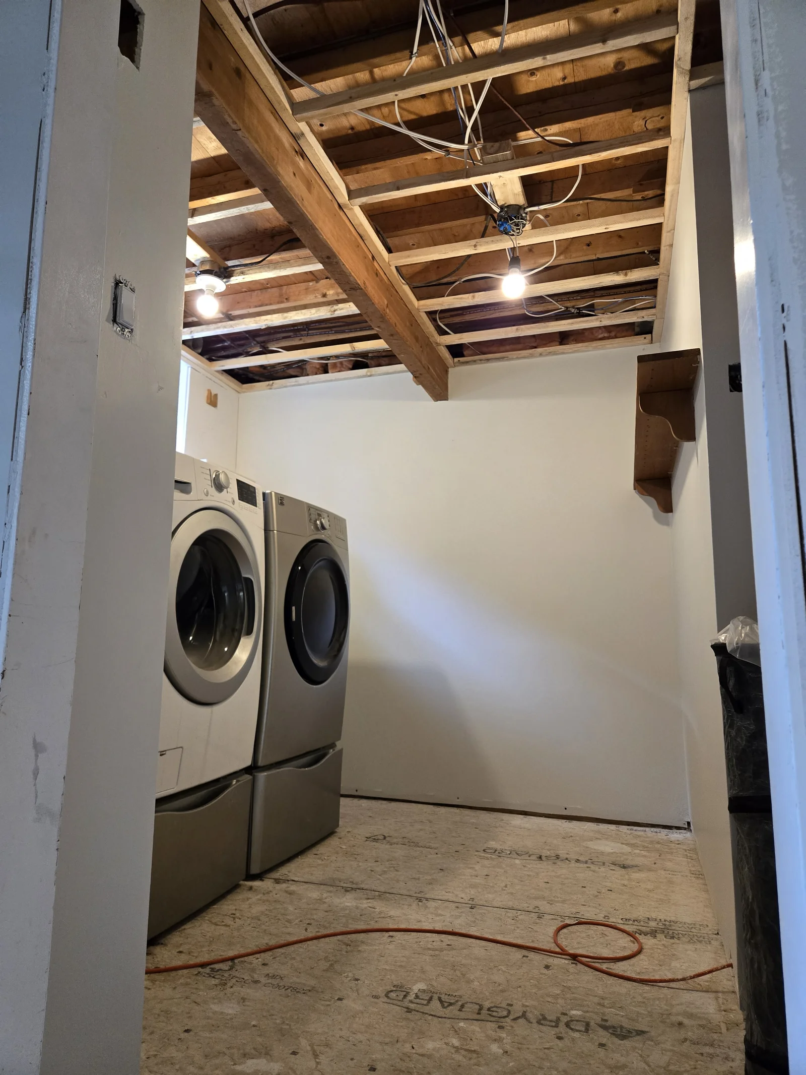 Laundry room with exposed ceiling joists and unfinished subfloor