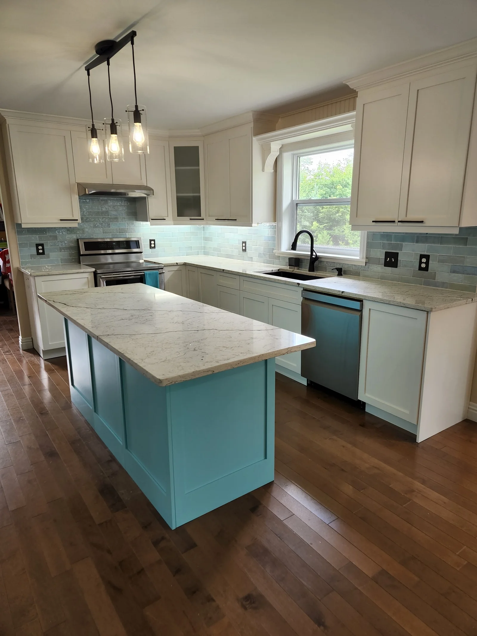 Finished white kitchen with teal island and tile backsplash